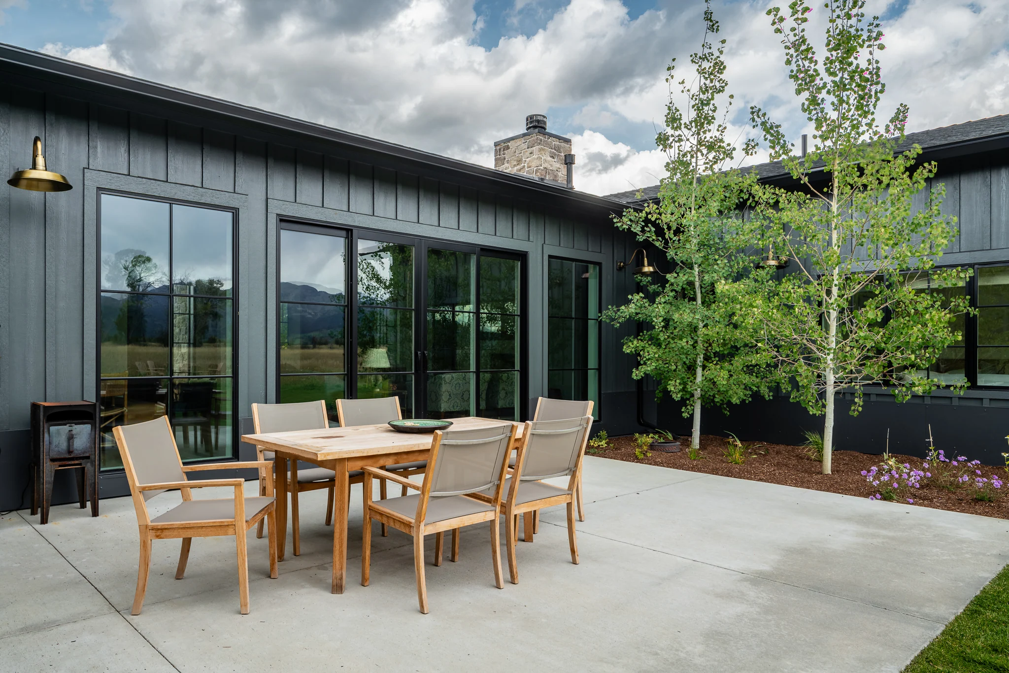 Exterior patio dining set beside sliding glass doors and aspens — architectural photography Driggs Idaho, River's Edge